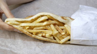 Kadın eli yakın çekimi Yunan Pita gyro 'sunu paketten aldı. konsept zararlı fast food.