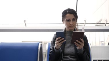 Havaalanında uçak bileti alan genç bir kadın bilet almak için pasaport bilgilerini giriyor..