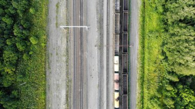 Aerial top down 4k view of railway tracks with an empty cargo wagons in summer.