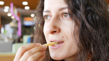 Genç, güzel esmer kız, fast food kafede gülümsüyor..