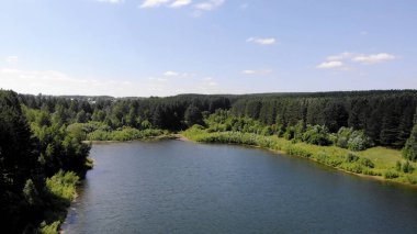 Ormanda güzel bir göl üzerinde 4K uçuş, yaz güneşli bir gün..