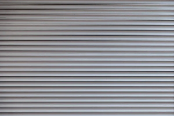 The texture of corrugated metal sheet, white or grey slide door Old roller shutter texture for background