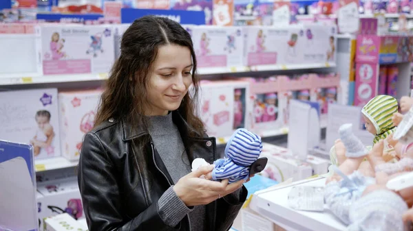 Genç bir kadın, kızım için bir oyuncak bebek seçti..