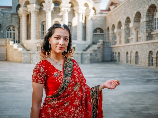 Beautiful ethnic Indian Saree. Young woman in red, colorful, sensual, wedding and very feminine outfit - Indian sari poses on old streets in India.