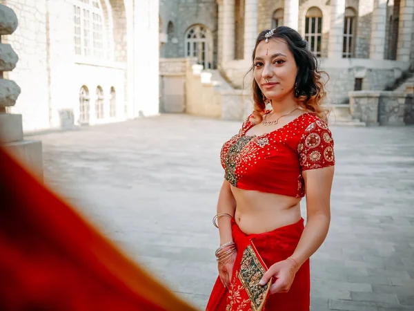 Beautiful ethnic Indian Saree. Young woman in red, colorful, sensual, wedding and very feminine outfit - Indian sari poses on old streets in India.