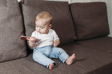 Yakışıklı çocuk cep telefonuyla oynuyor. Yakın plan.