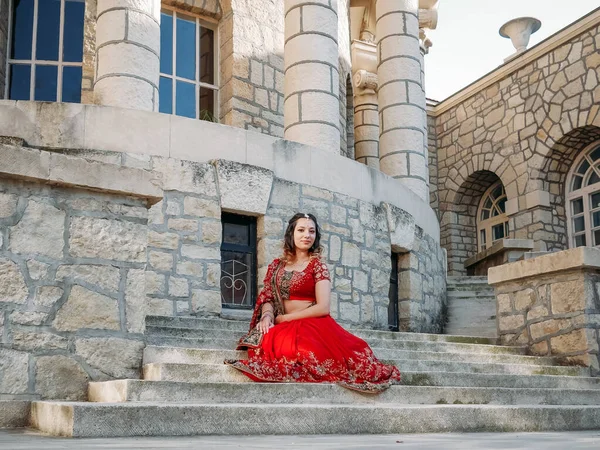 Beautiful ethnic Indian Saree. Young woman in red, colorful, sensual, wedding and very feminine outfit - Indian sari poses on old streets in India.