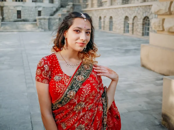 Beautiful ethnic Indian Saree. Young woman in red, colorful, sensual, wedding and very feminine outfit - Indian sari poses on old streets in India.