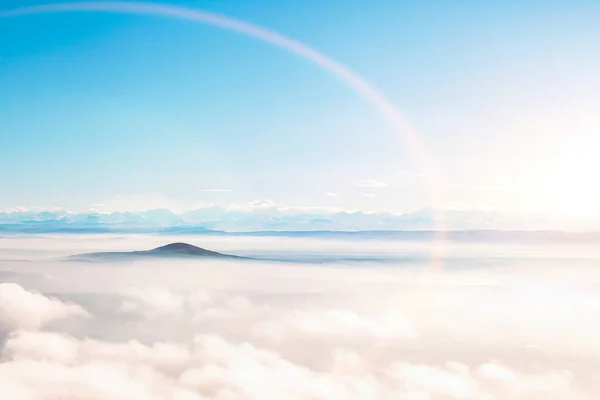 飛行機の窓から見た青空の夕日の雲と山脈の空の景色 — ストック写真