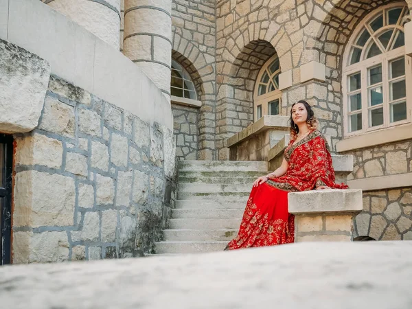 Beautiful ethnic Indian Saree. Young woman in red, colorful, sensual, wedding and very feminine outfit - Indian sari poses on old streets in India.