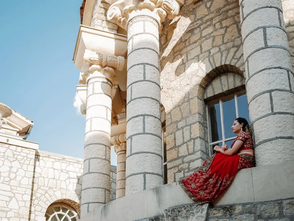 Beautiful ethnic Indian Saree. Young woman in red, colorful, sensual, wedding and very feminine outfit - Indian sari poses on old streets in India.