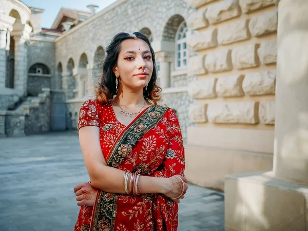 Beautiful ethnic Indian Saree. Young woman in red, colorful, sensual, wedding and very feminine outfit - Indian sari poses on old streets in India.