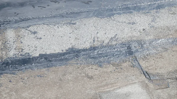 Working seals cracks on the roof with the help of melted tar. Roof repair