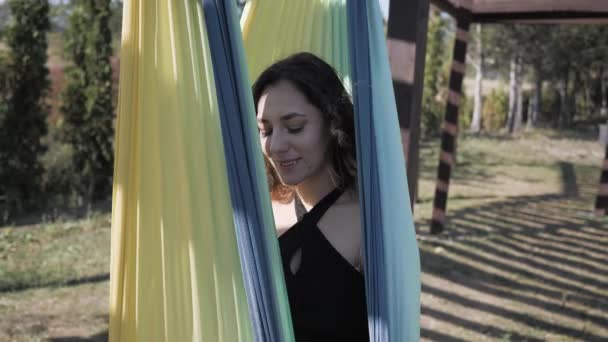 Jeune athlète féminine se détend sur hamac dans le parc pendant l'entraînement — Video