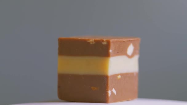 Dulces de chocolate aislados sobre fondo blanco, macro, rotación. Postre dulce — Vídeo de stock