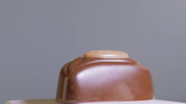 白い背景に隔離されたチョコレートキャンディー、マクロ、回転。甘いデザート — ストック動画