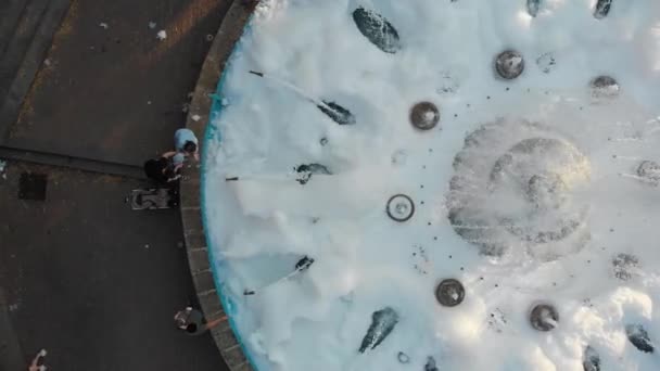 Vista aérea de cima para baixo 4k de uma fonte da cidade cheia de água e espuma com pessoas andando por aí. Rússia, Stavropol - 25.08.2020 — Vídeo de Stock