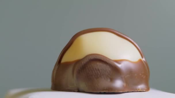 Deliciosos deliciosos chocolates artesanais isolados em fundo branco, macro, rotação. Fabricação de brindes de chocolate premium. Doce sobremesa — Vídeo de Stock