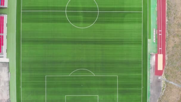 Vista aérea de arriba abajo de 4k de un campo de fútbol con un césped verde. Volando sobre un campo de deportes — Vídeos de Stock