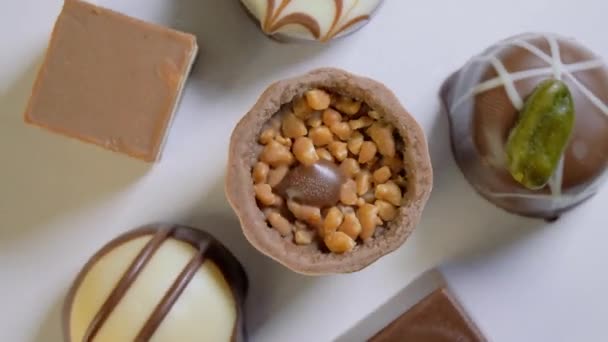 El primer plano de los bombones de chocolate con relleno gira sobre fondo blanco. Fondo de postre de comida. Regalo de vacaciones. — Vídeos de Stock