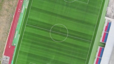 Boş futbol sahasında uçan hava aracı. İnsan yok. Yukarıdan yeni bir futbol stadyumu geliyor.