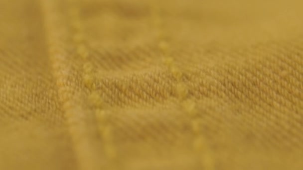 Makro öltés narancs farmer szövet részletek. textil textúra. a varróműhely koncepciója. Homályos, szelektív fókusz. — Stock videók
