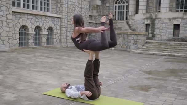 职业杂技瑜伽。合身的高加索夫妇练习木板鸟姿势，在室外垫子上一起做仰卧起坐练习 — 图库视频影像