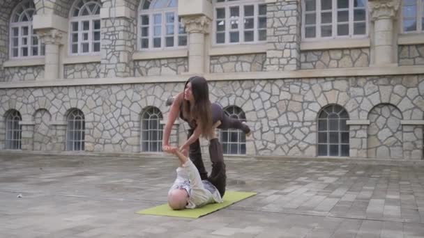Fit sportief paar oefenen acro yoga met partner samen op mat, jongeman houden vrouwen balanceren op zijn voeten, acrobatische oefening ster in yoga — Stockvideo