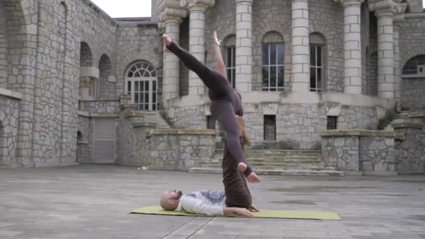 Akrobatická jóga pro páry. Pose of asana "star". Jóga pózuje pro dva muže a ženy. Venku — Stock video