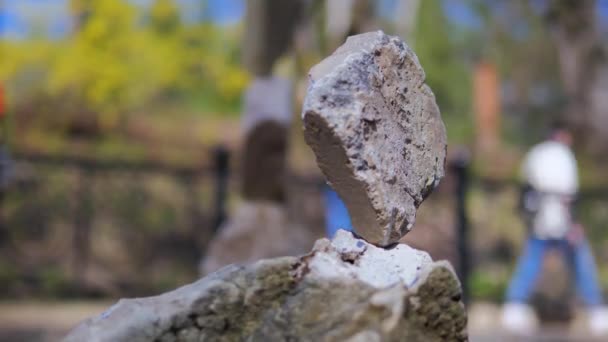 Pirámide de piedras en el fondo de la gente caminando de cerca — Vídeo de stock