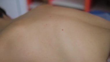 Genç bir kadının sırtına kadın eli masajı. Üst Manzara. Vücut bakımı kavramı.