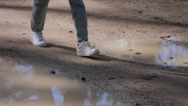 Donna piedi camminando sulla strada fangosa attraverso pozzanghere e fango, nessun concetto strade — Video Stock