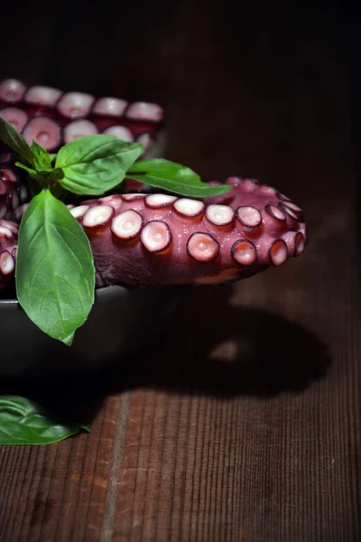 Тарелка, полная осьминога с листьями базилика — стоковое фото
