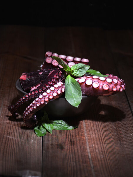 Тарелка, полная осьминога с листьями базилика
 