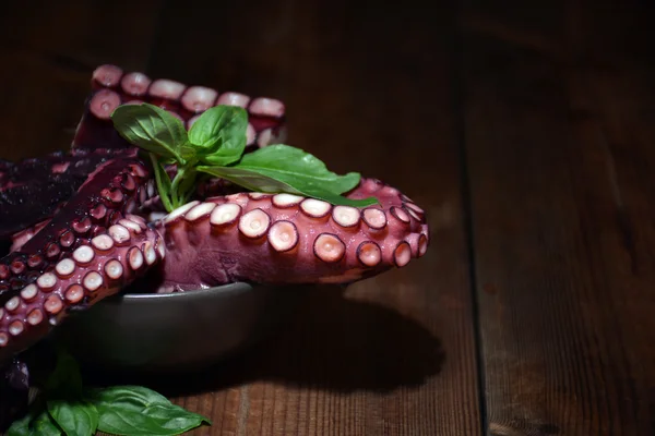 Assiette pleine de poulpe avec des feuilles de basilic — Photo