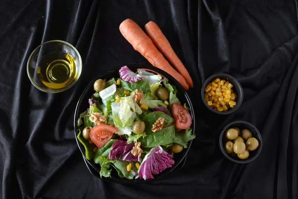 Plato de ensalada con lechuga, tomate, aceitunas y aceite . — Foto de Stock