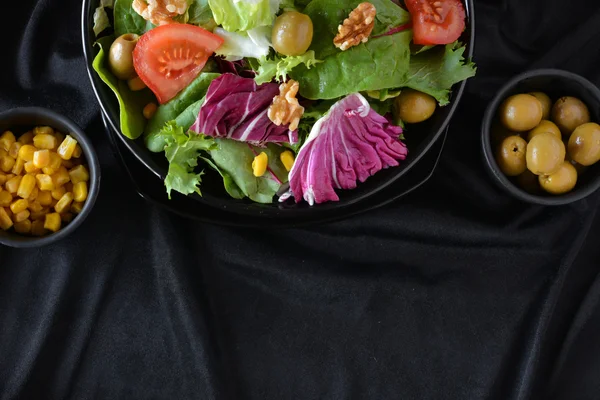 Plato de ensalada con lechuga, tomate, aceitunas y aceite . — Foto de Stock