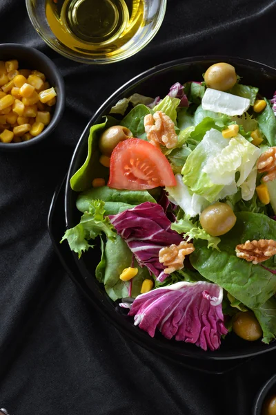 Plato de ensalada con lechuga, tomate, aceitunas y aceite . — Foto de Stock