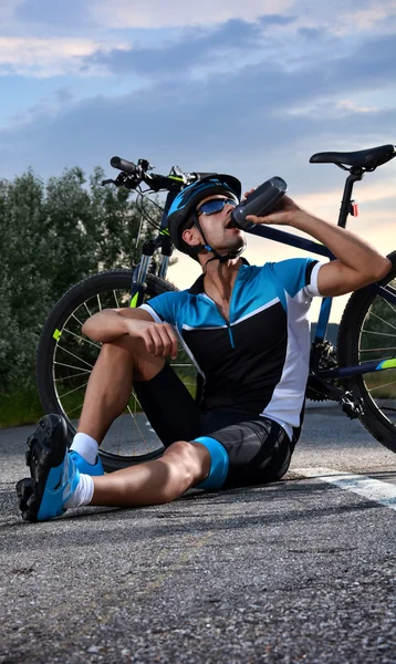 Ciclista que va en bicicleta de montaña a lo largo de un camino solitario —  Fotos de Stock