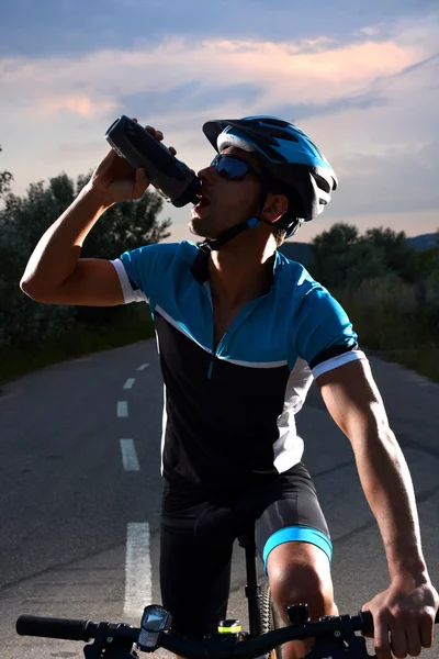 Ciclista que va en bicicleta de montaña a lo largo de un camino solitario —  Fotos de Stock