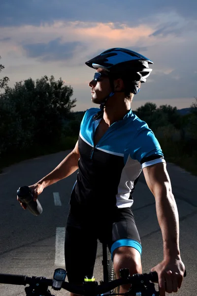 Ciclista que va en bicicleta de montaña a lo largo de un camino solitario —  Fotos de Stock
