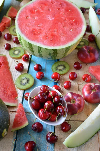 Table rustique pleine de morceaux de pastèque, melon — Photo