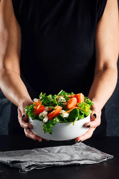 トマト レタス オリーブオイル 塩とサラダを準備する女性健康的な食事の概念 ロイヤリティフリーのストック画像
