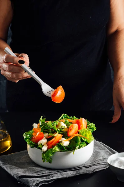 トマト レタス オリーブオイル 塩とサラダを準備する女性健康的な食事の概念 ロイヤリティフリーのストック写真