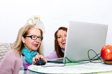 78 yaşında bir büyükanne kızıyla birlikte evde bilgisayar kullanmayı öğreniyor.