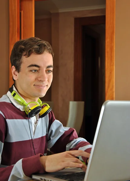 Jovem estudando em casa com seu computador — Fotografia de Stock