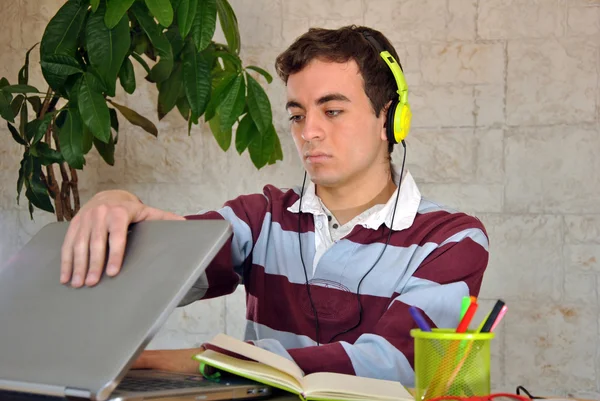 Молодой человек учится дома с компьютером — стоковое фото