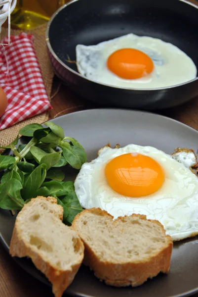 Жареные яйца с тарелкой, хлебом и маслом — стоковое фото