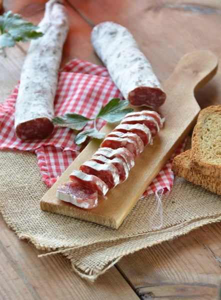 Salame fuet espanhol em uma tábua de corte — Fotografia de Stock