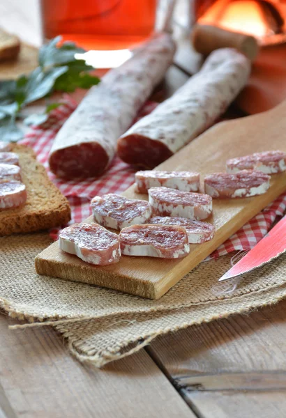 Salame fuet espanhol em uma tábua de corte — Fotografia de Stock